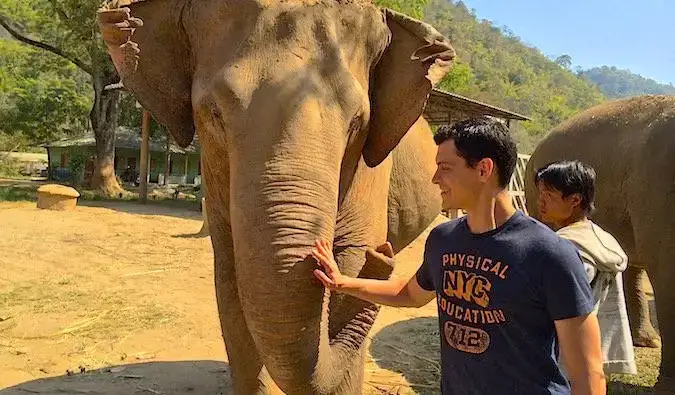 Le nomade Matt Kepnes joue avec un éléphant thaïlandais au Elephant Nature Park