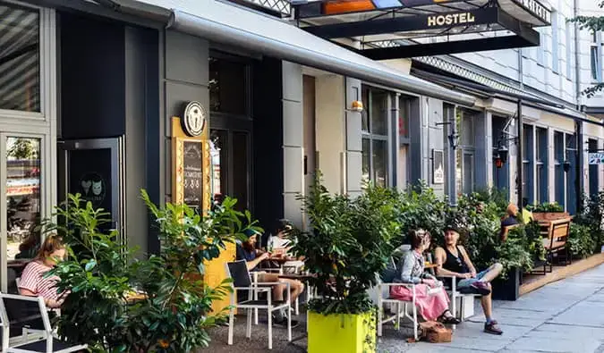 Des gens assis à des tables sur la terrasse du trottoir à l'extérieur du Circus Hostel, Berlin
