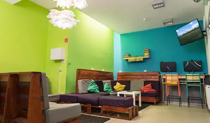 Espace commun avec canapés, télévision et deux ordinateurs à l'Hostel One, Budapest