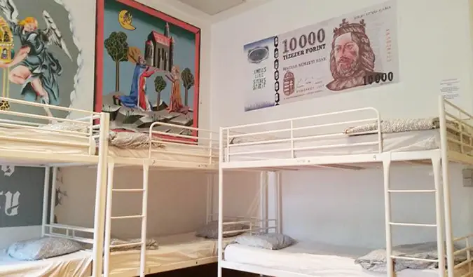 Lits superposés dans un dortoir avec des peintures hongroises sur les murs du Vitae Hostel, Budapest