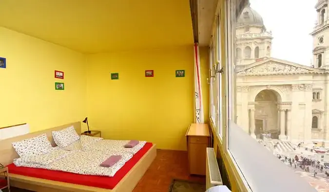 Chambre double aux couleurs vives avec fenêtre donnant sur la ville à Pal