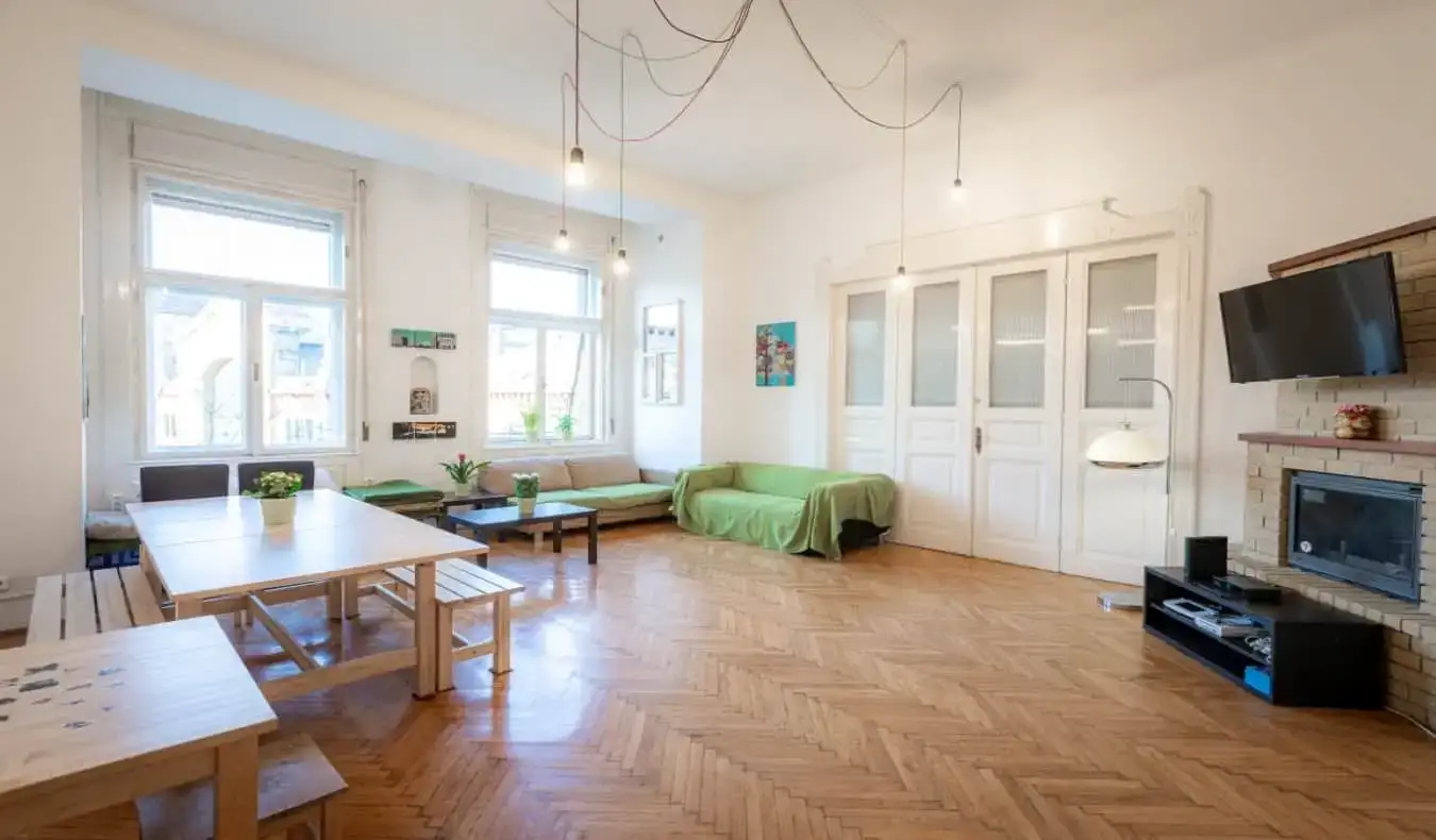 Salle commune bien éclairée avec canapés et tables au Spicy Hostel à Budapest
