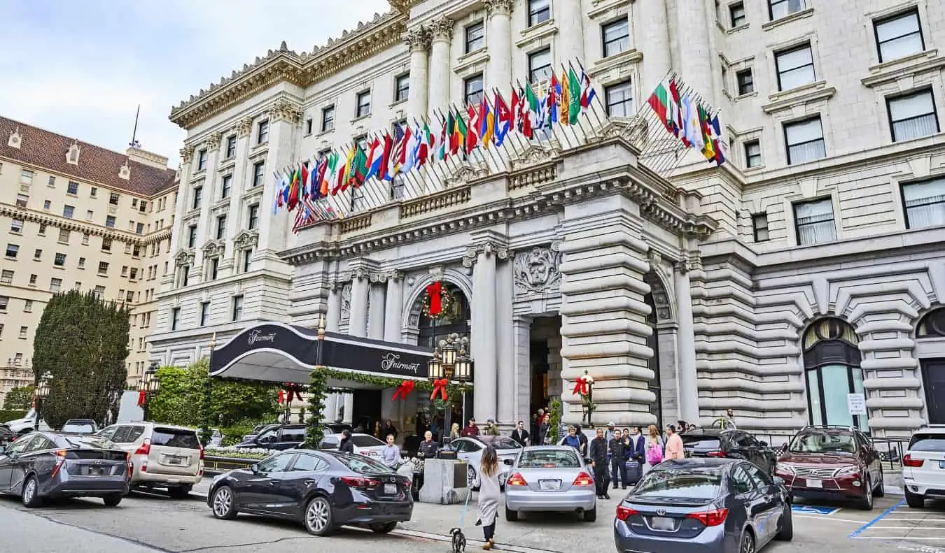 Le majestueux hôtel Fairmont à Nob Hill, San Francisco, avec des dizaines de drapeaux nationaux flottants et des voitures de luxe garées devant