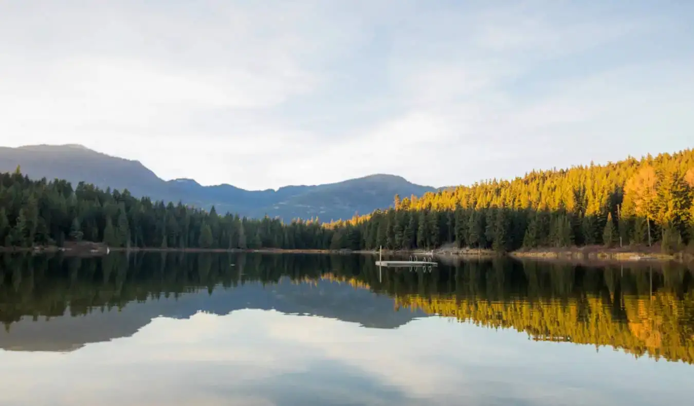 Sebuah danau yang tenang dengan dermaga terapung kecil di dekat Whistler, BC, Kanada
