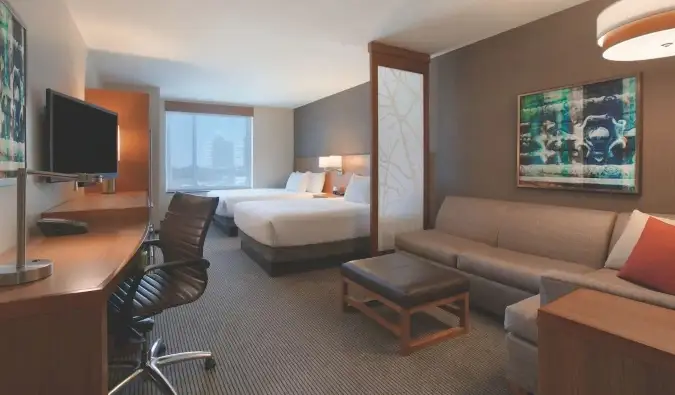 Gæsteværelse på Hyatt Place Chicago South med to queensize-senge, et skrivebord og en stor sektionssofa