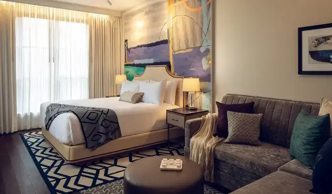 Deluxe kingsize-værelse på Sophy Hyde Park-hotellet i Chicago, indrettet i en moderne stil med en king-size seng og en grå sektionssofa