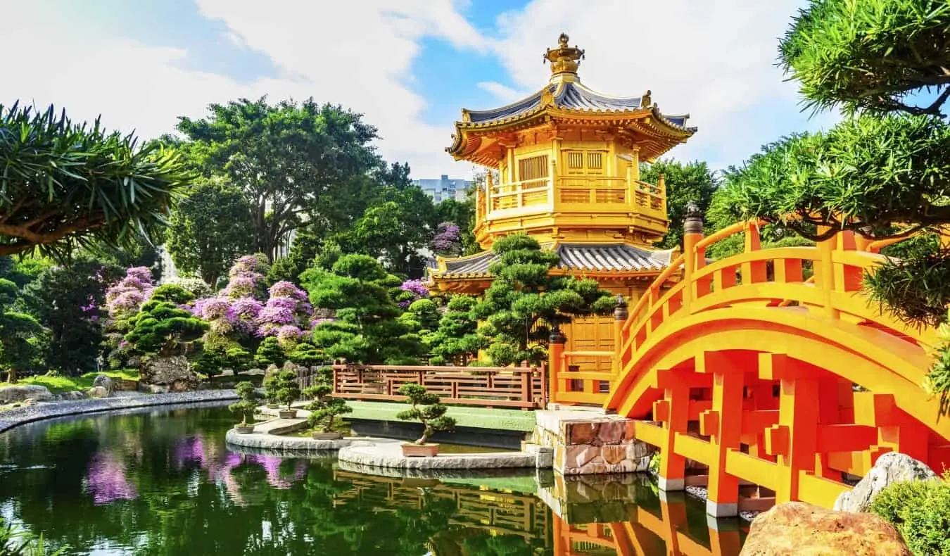 Pagode d'or avec un pont passant au-dessus d'un bassin réfléchissant au jardin Nan Lian dans le parc de Kowloon, Hong Kong