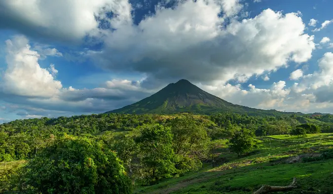 Un volcan solitaire au loin surplombant une jungle luxuriante