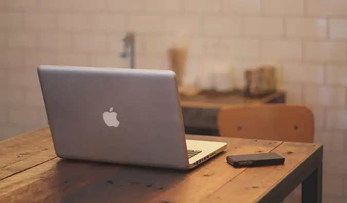 klēpjdators uz galda blakus mobilajam tālrunim
