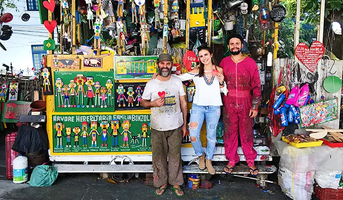 Celinne da Costa posando com alguns moradores locais em sua pequena barraca de souvenirs
