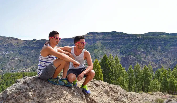 Auston et David de deux mauvais touristes posant sur une falaise lors d'une randonnée