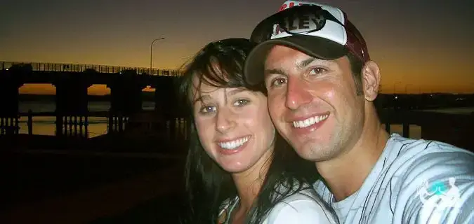 Un couple voyageur posant ensemble devant le coucher de soleil à l'étranger