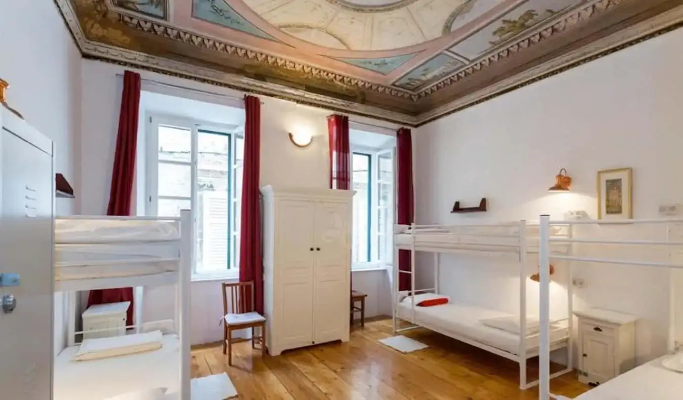 Dortoir avec lits superposés, parquet et plafond orné de l'Old Town Hostel à Dubrovnik, en Croatie.