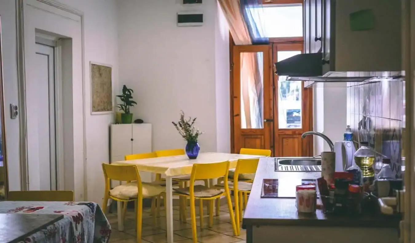 Coin cuisine chaleureux avec une table jaune vif et des portes en bois chez Anchi