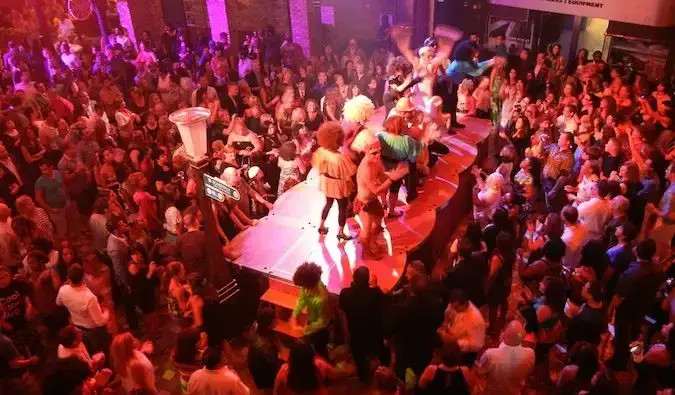 クルーズ船の満員のダンスフロア、テーブルで踊る女性たち