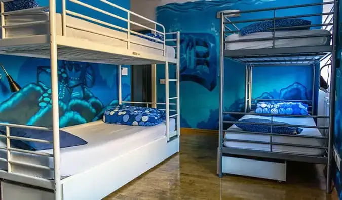 2 lits superposés dans une chambre aux murs bleu vif de l'auberge Madhouse Prague à Prague.