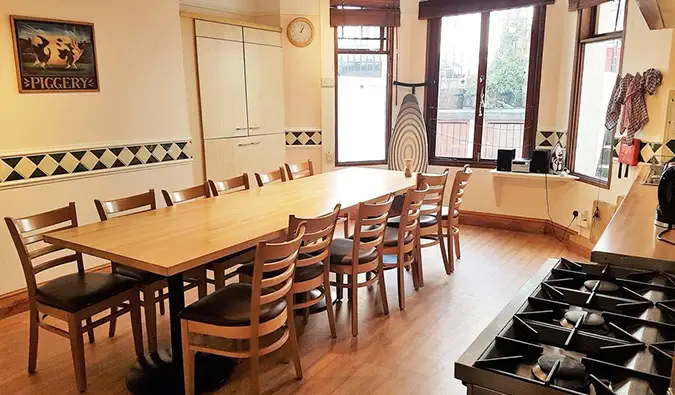 Coin cuisine avec longue table en bois et baies vitrées à Barmy Badger, Londres