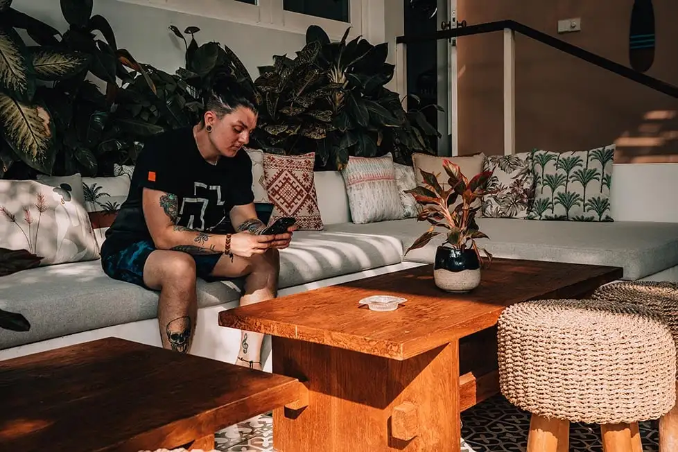 Nic sentado olhando para o telefone em uma vila