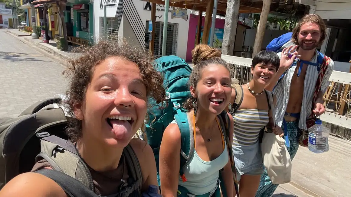 quatro amigos andando pelas ruas de El Salvador com mochilas nas costas