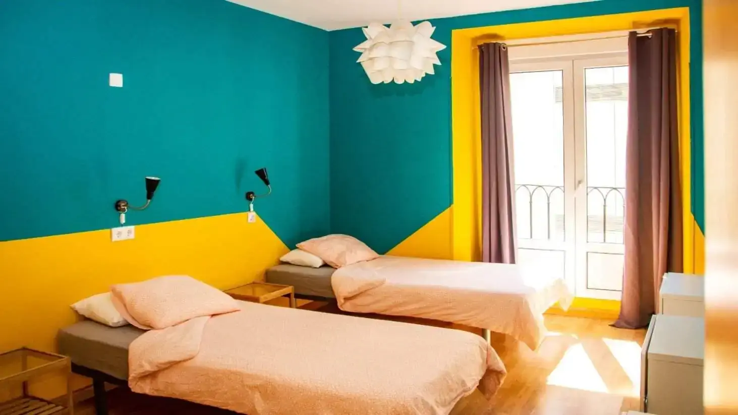 Deux lits jumeaux dans une chambre aux couleurs vives de l'auberge Sungate One à Madrid, en Espagne.