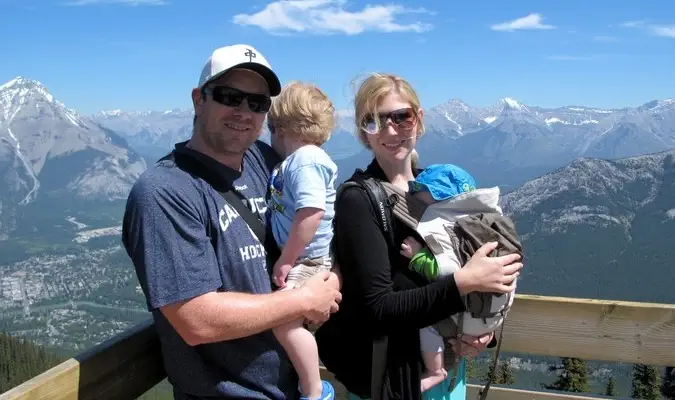 Reisende familie på fire foran snødekket fjellkjede