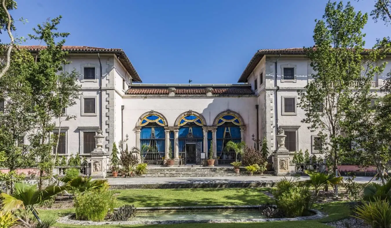 Vizcaya Estate dengan atap terakota dan pintu melengkung besar di bawah langit biru di Miami, Florida.