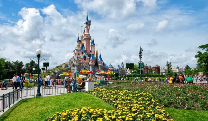 Malowniczy zamek w sercu Disneylandu w Paryżu, otoczony kwiatami we Francji