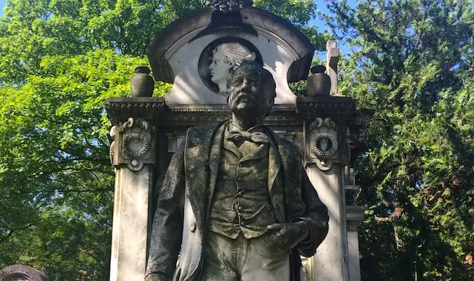 Uma velha estátua num enorme cemitério em Paris, França