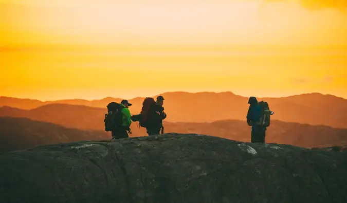 un groupe de voyageurs en randonnée au coucher du soleil en Norvège