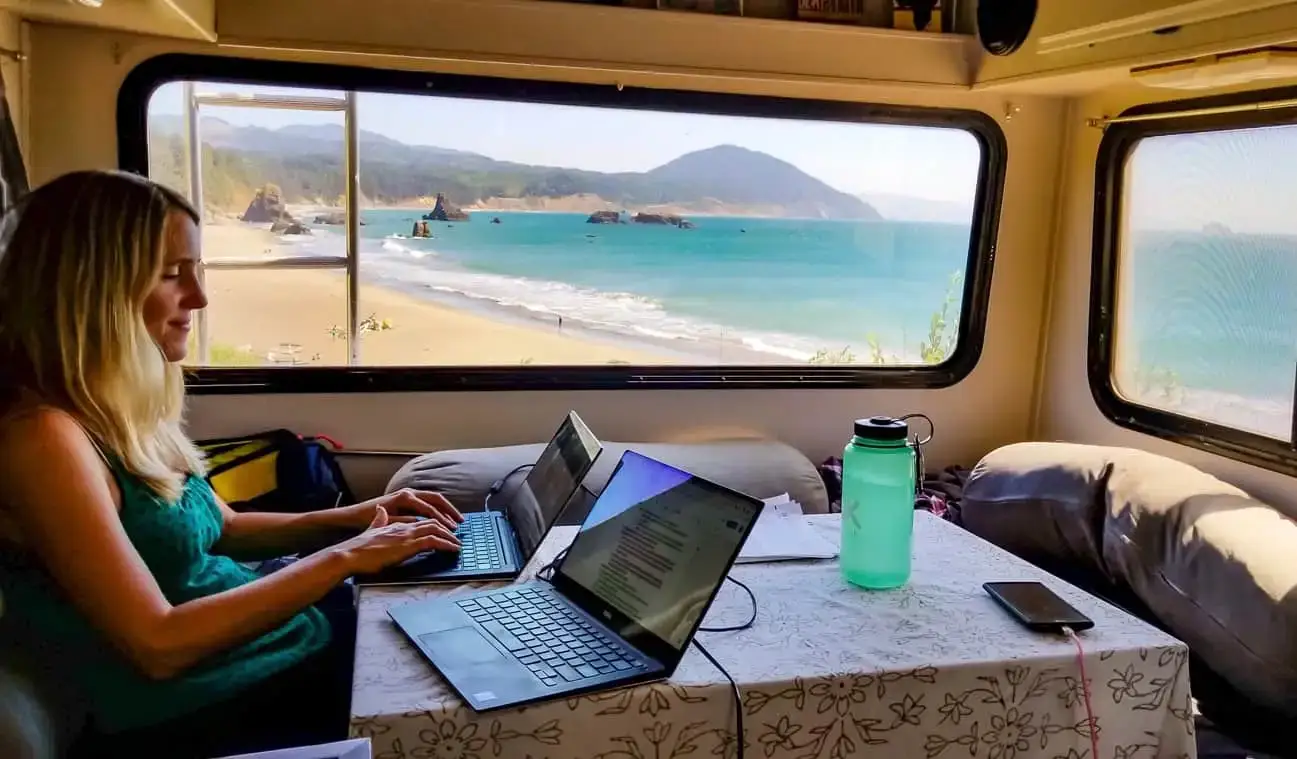 Anne de HoneyTrek travaillant sur un ordinateur portable dans son camping-car