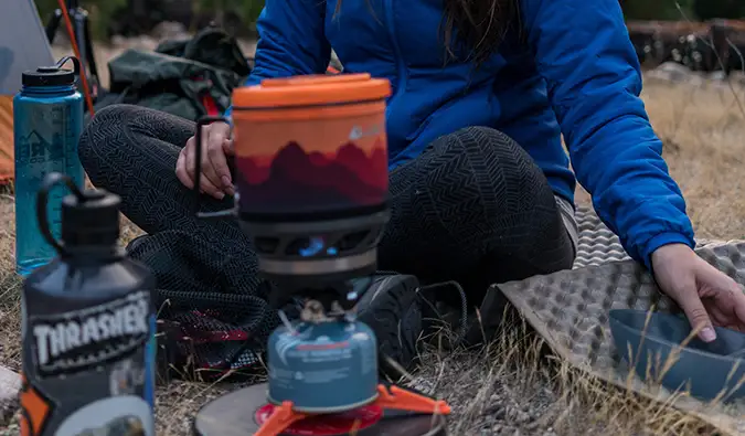 une femme installant un feu de camp en camping