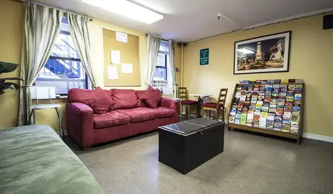 Espace commun basique avec canapés et support de brochures au Chelsea Hostel à New York