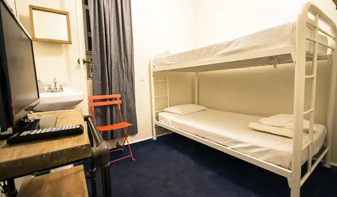 Petite chambre avec lits superposés et bureau avec écran d'ordinateur à l'American Dream B&B à New York
