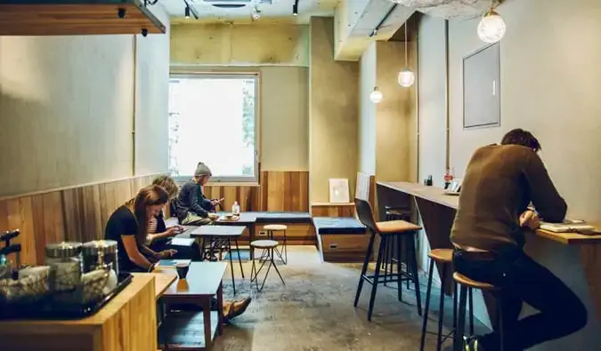 Voyageurs et clients assis dans le salon de l'auberge CITAN à Tokyo, Japon