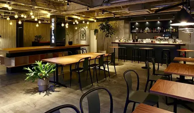 Le salon élégant avec de nombreuses tables en bois chez Unplan Kagurazaka à Tokyo, Japon