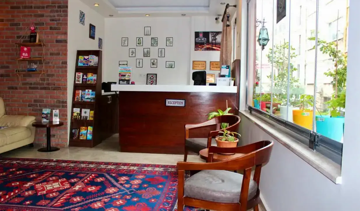 Receptionen på Stanpoli Hostel, med en färgglad matta nära ingången i Istanbul, Turkiet