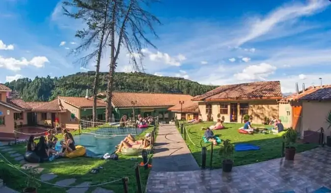 Vaste jardin avec des gens jouant à des jeux de jardin et se prélassant à Wild Rover, une auberge de jeunesse à Cusco, Pérou