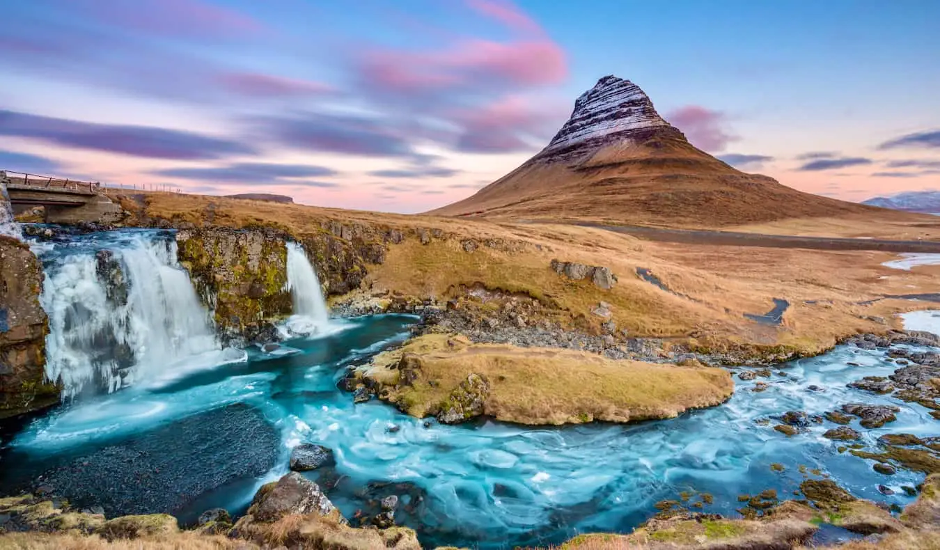 La célèbre montagne Kirkjufell en Islande au coucher du soleil, au milieu d'un paysage accidenté