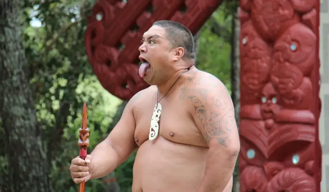 Egy nagydarab maori harcos, aki lándzsát tart, miközben fellép Új-Zélandon