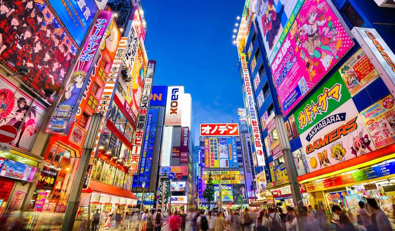 Une rue lumineuse et animée éclairée la nuit avec des enseignes au néon à Tokyo, Japon