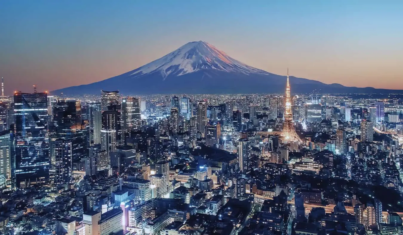 L'horizon tentaculaire de Tokyo, au Japon, s'illumine la nuit avec le mont Fuji au loin