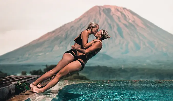 Charlotte et Natalie plongent dans une piscine devant un volcan à Bali