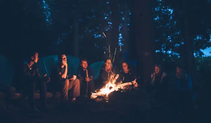 Un groupe d'amis et de voyageurs assis près d'un feu la nuit