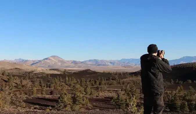 El viajero vegano Chris Oldfield tomando una foto en un parque nacional de EE. UU.