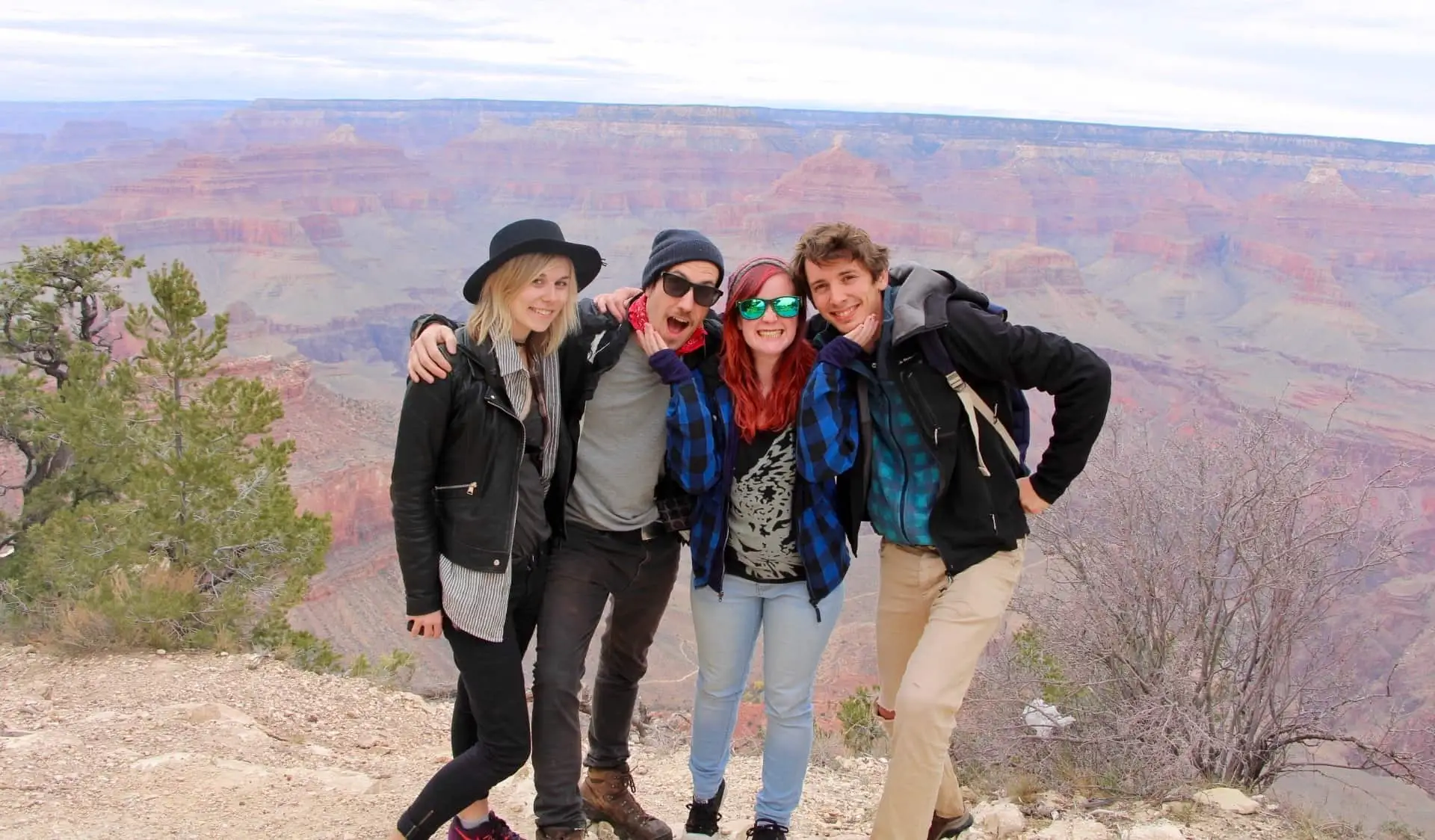 Un grupo de viajeros posando para una foto en el Gran Cañón de EE.UU.