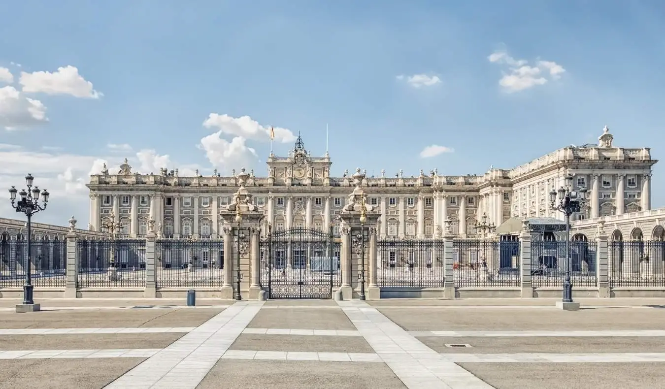 La façade en pierre du Palais Royal, avec des pins devant, à Madrid, Espagne