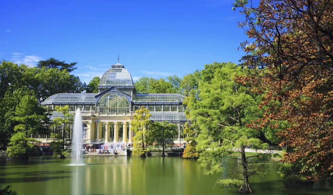 Le Crystal Palace en verre surplombe un petit étang entouré d'arbres dans le parc du Retiro à Madrid, Espagne