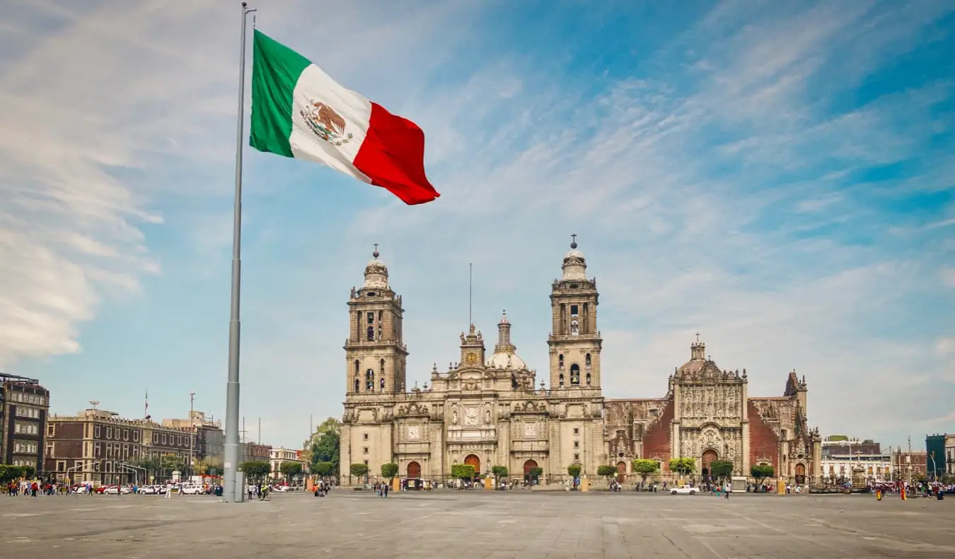 Et stort meksikansk flagg foran en av de mange historiske bygningene i Mexico City, Mexico