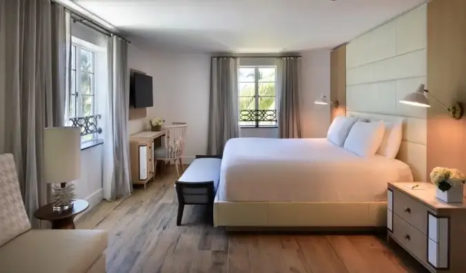 Chambre d'hôtel à l'Hôtel Ocean à Miami, avec un lit queen size et un bureau et décorée dans des tons neutres et chauds