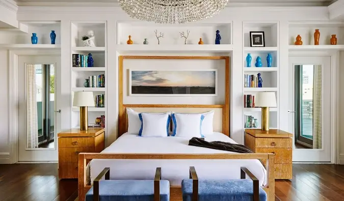 Lit queen size avec étagère derrière recouverte de différentes œuvres d'art à l'hôtel Betsy à Miami, Floride